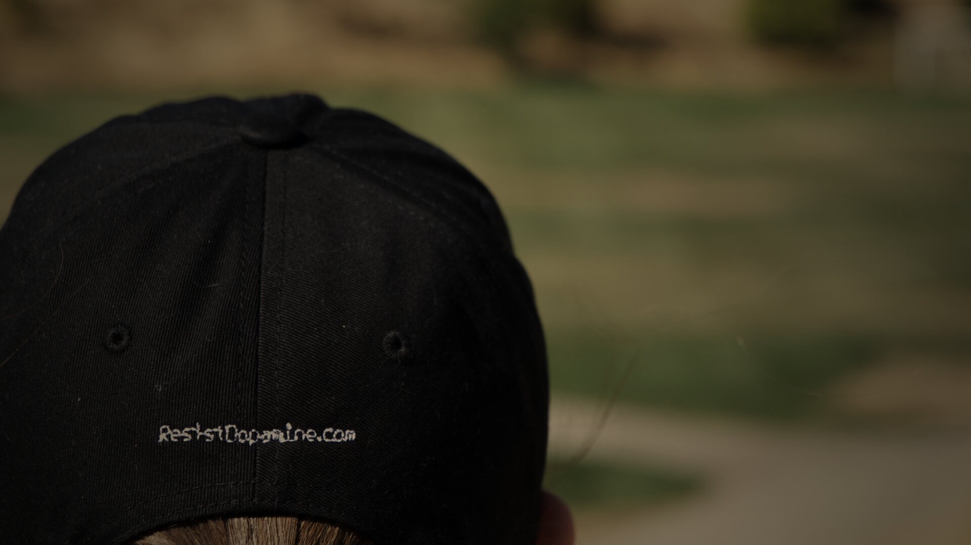 The back of the hat, resistdopamine.com stitched above the strap